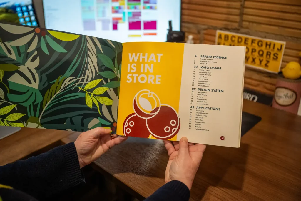 Close-up of the Kokada brand style guide held open to the table of contents, showing the depth and complexity of the document.