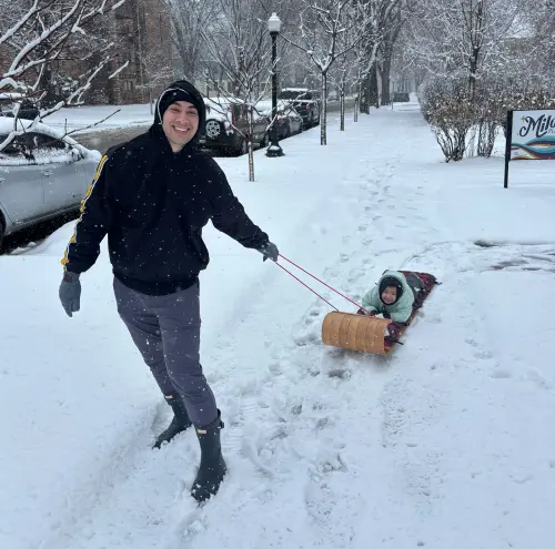 andrew pulling mari on a sled